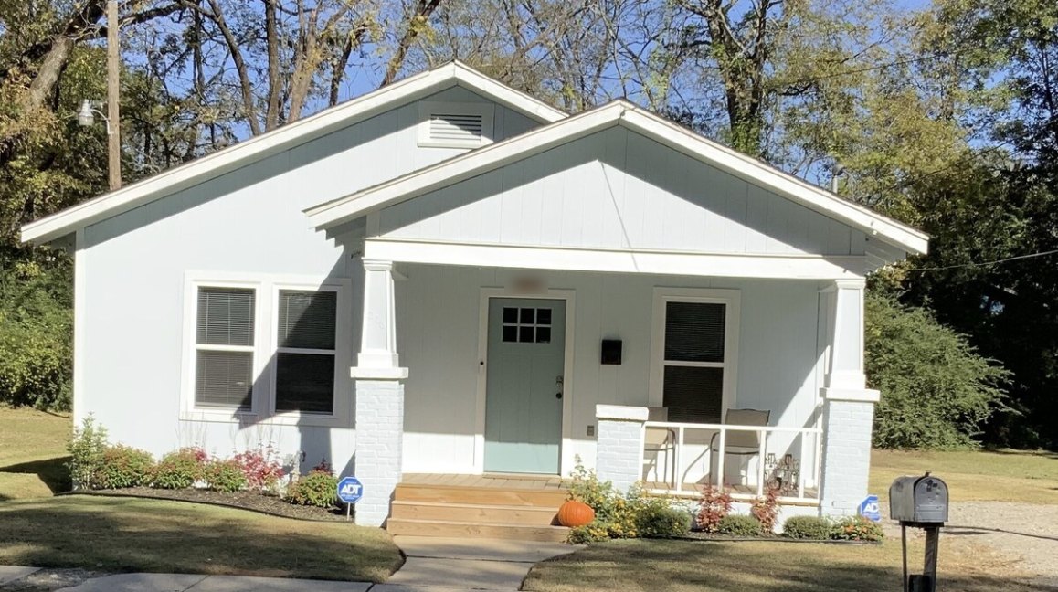 Aunt Elaine's Downtown Cottage: a light blue bungalow with a front porch and a seafoam door