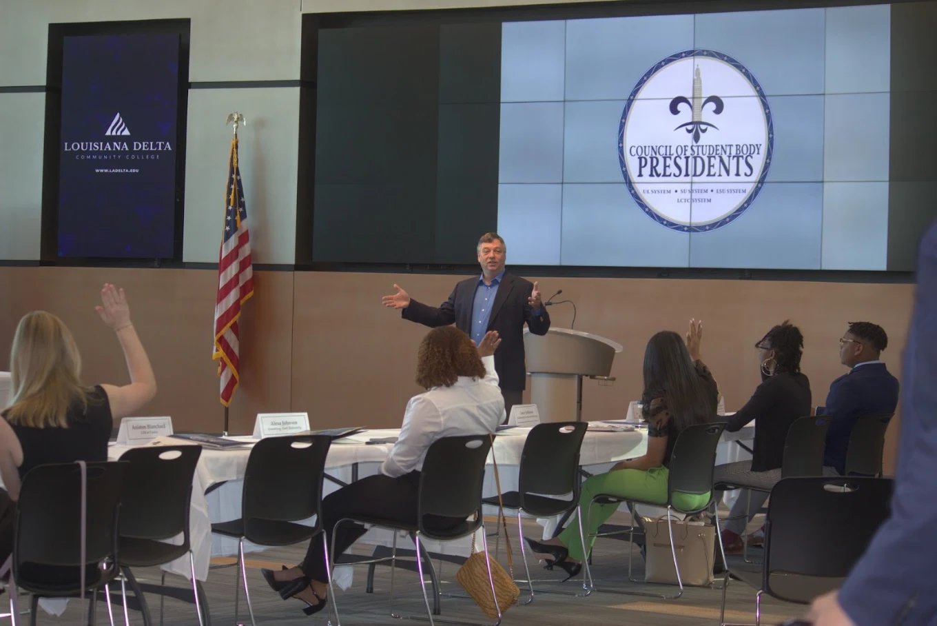 Students raising their hands during a presentation at a Louisiana Delta Community College event